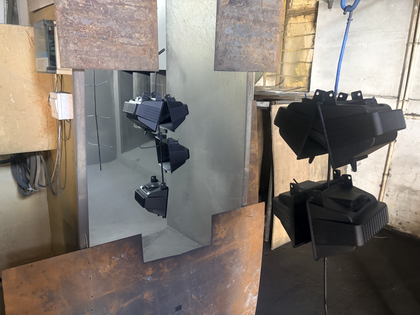 Finished black powder-coated professional LED work light housings hanging for inspection