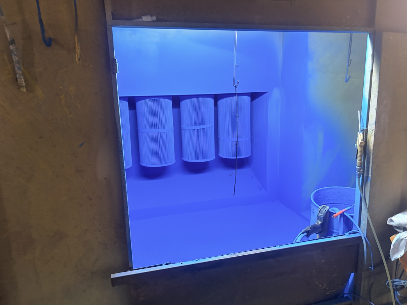 Powder application booth with filtration equipment for metal lighting components